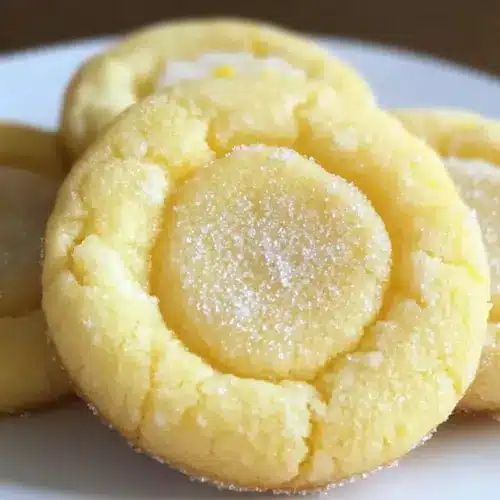 Zitronen-Zucker-Kekse Rezept Zutaten: - 2 1/2 Tassen Mehl - 1 Teelöffel Backpulver - 1/2 Teelöffel Salz - 1 Tasse Butter, weich - 1 Tasse Zucker - 1 großes Ei - 1 Teelöffel Vanilleextrakt - 1 Esslöffel Zitronenschale - 1/4 Tasse Zitronensaft - Zucker zum Bestreuen Anleitung: 1. Ofen auf 175 Grad Celsius vorheizen. 2. In einer Schüssel Mehl, Backpulver und Salz vermengen. 3. In einer anderen Schüssel Butter und Zucker cremig rühren. 4. Ei, Vanilleextrakt, Zitronenschale und Zitronensaft hinzufügen und gut vermischen. 5. Trockene Zutaten nach und nach einrühren, bis alles gut kombiniert ist. 6. Teig zu kleinen Kugeln formen und auf ein Backblech legen. 7. Mit Zucker bestreuen. 8. 8-10 Minuten backen, bis die Kekse leicht goldbraun sind. 9. Abkühlen lassen und genießen.